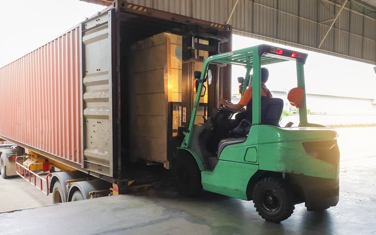 Forklift Driver Loading Goods Pallet Into The Truck Container, Freight Industry Warehouse Logistics And Transport