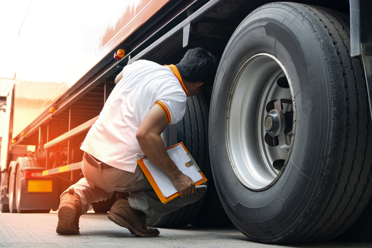 Truck Diver Inspecting Safety Daily Check A Truck Tires.