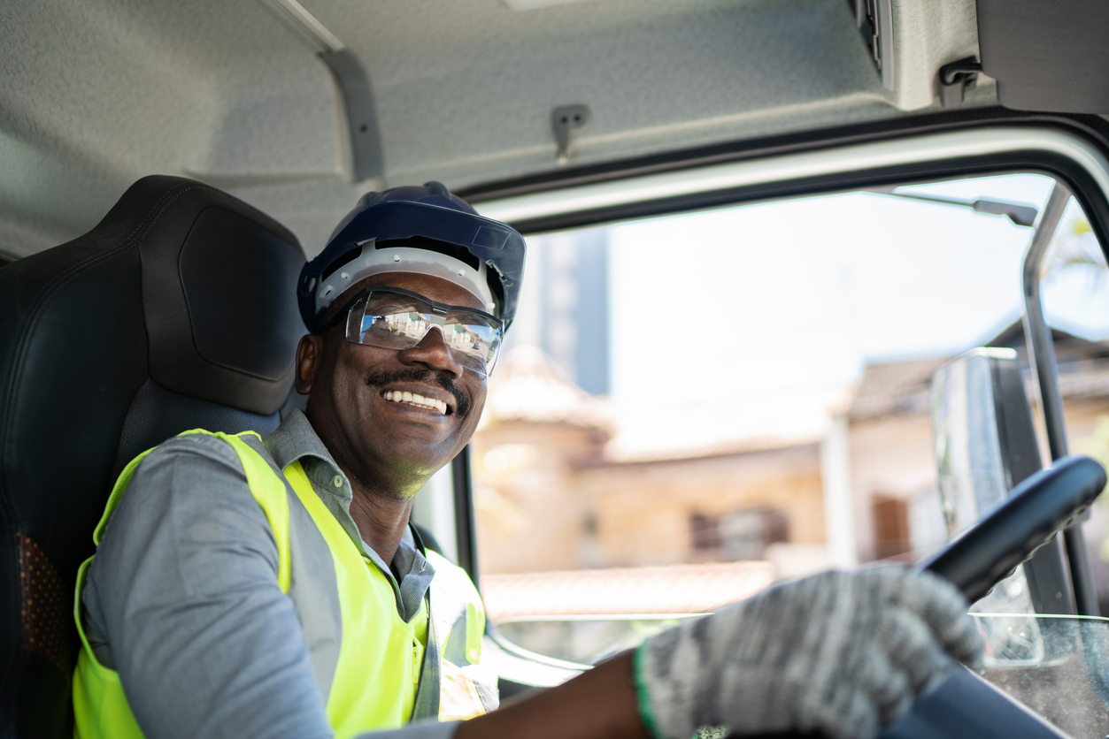 Portrait Of A Truck Driver Inside The Truck At A Construction Site