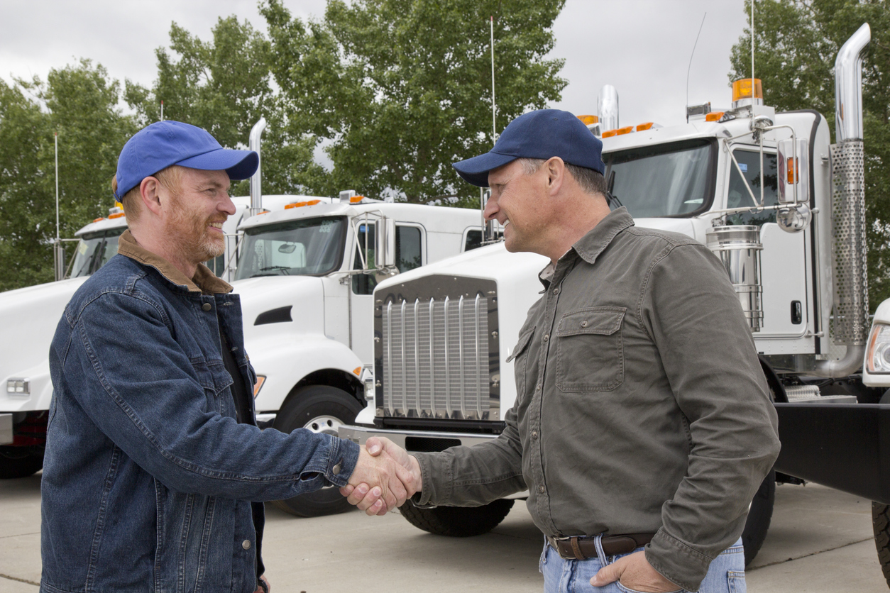 Friendly Trucker Handshake And Cooperation In Front Of Semi Truck