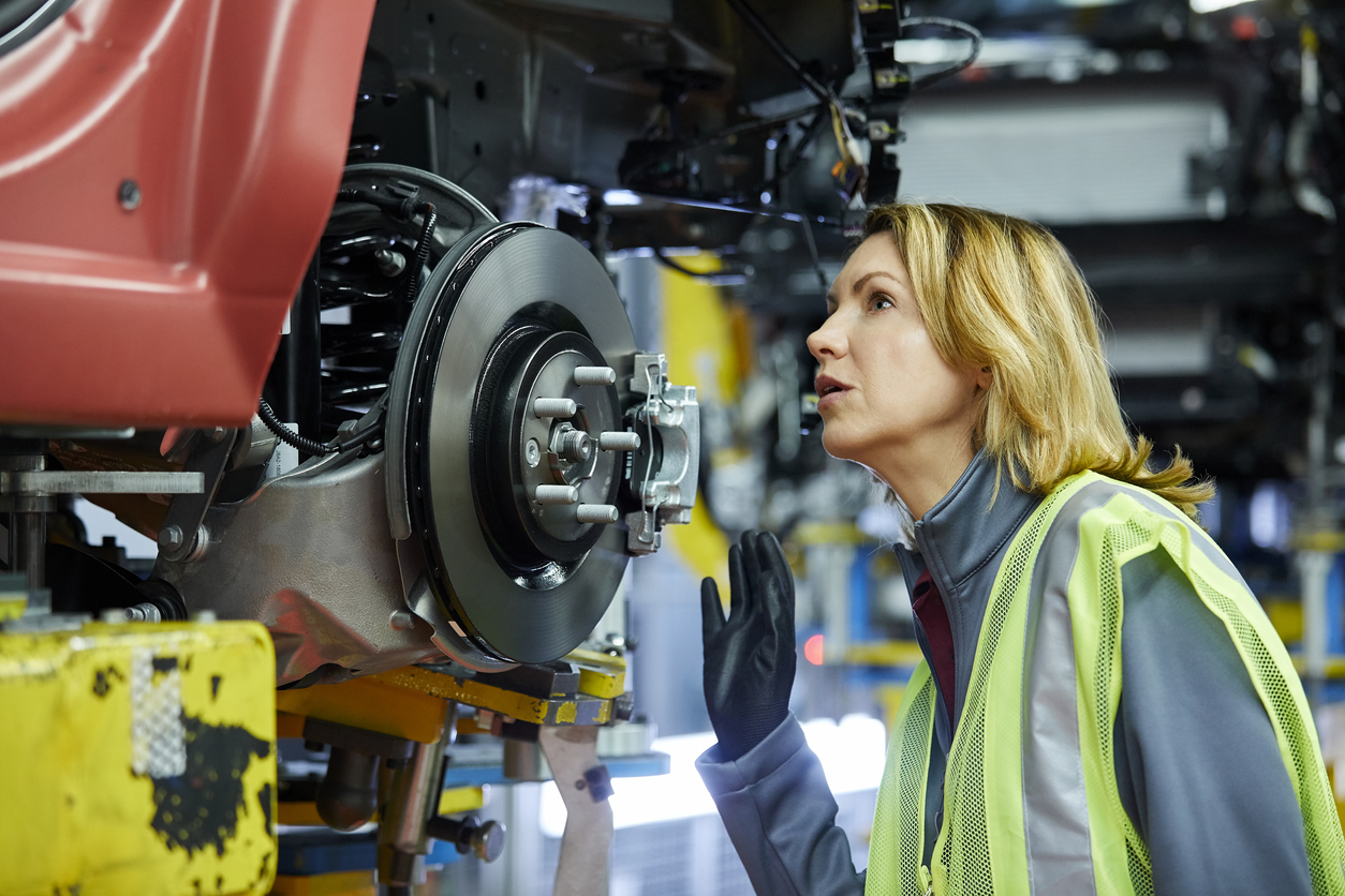 Blond Female Engineer Checking Vehicle At Factory