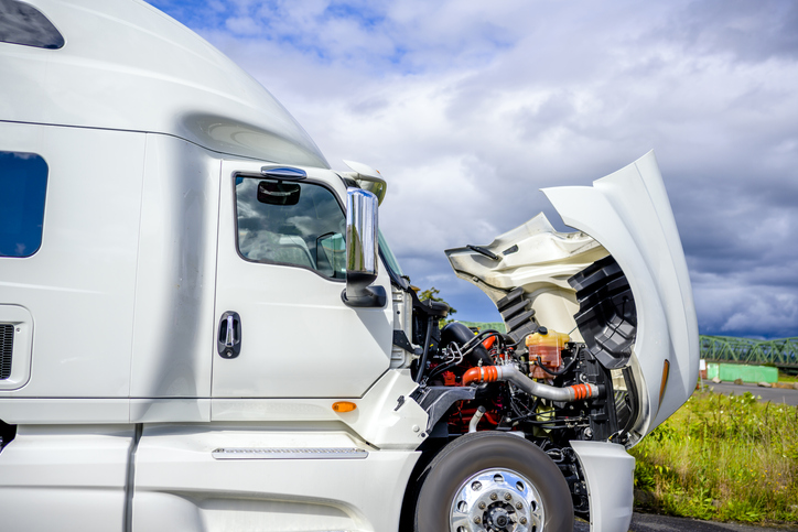 Broken White Big Rig Semi Truck Tractor Stands On The Side Of The Road With An Open Hood Awaiting Mobile Repair Assistance