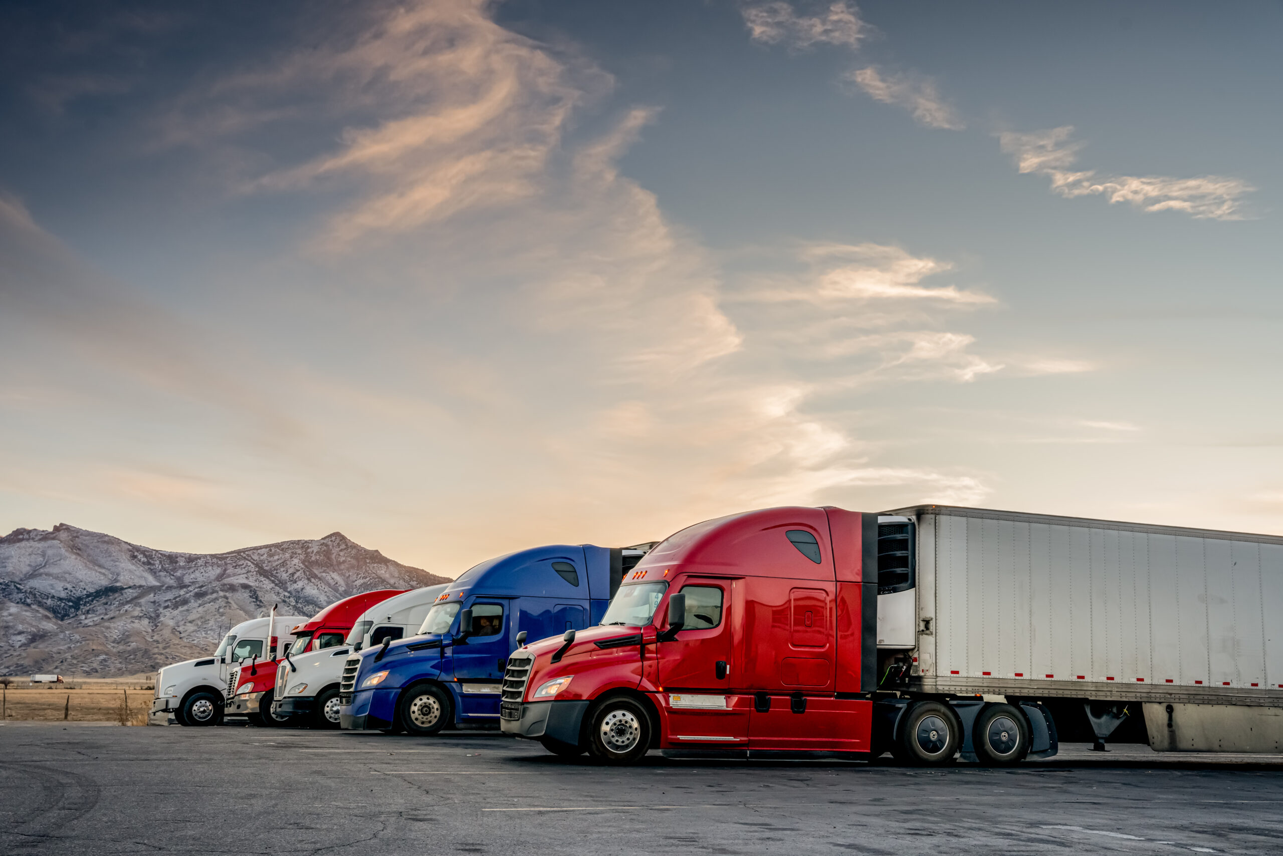 Red White And Blue Parked Trucks Lined Up At A Truck Stop