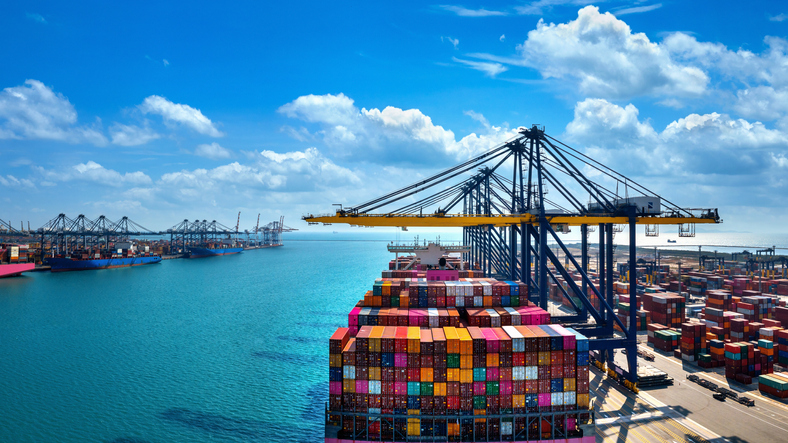 Aerial View Of Cargo Ship And Cargo Container In Harbor.