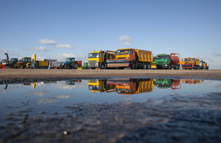 Colorful Cars. Snowblower. Large Snow Removal Machines At The Airport. Road Equipment. Grader, Dump Truck, Tractor. New Car Reflected In A Puddle. Reflection.