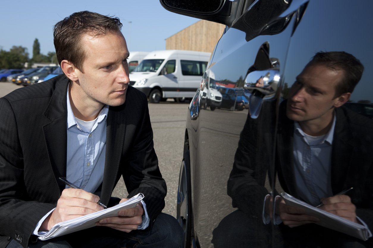 Insurance Agent Looks At Car